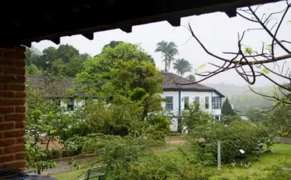 Fazenda Santa Rita: O refúgio colonial de 1860 com cachoeiras secretas em Muqui 7 Fachada do casarão histórico da Fazenda Santa Rita em Muqui, cercado por natureza e jardins.