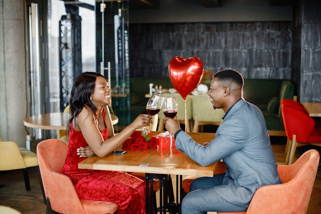 casal negro romantico sentado no restaurante vestindo roupas elegantes