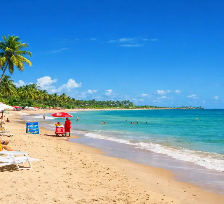 "Paisagem panorâmica da Praia de Taperapuã em Porto Seguro com céu azul vibrante e mar calmo, ilustrando a melhor época para viajar para a Bahia sem chuvas."