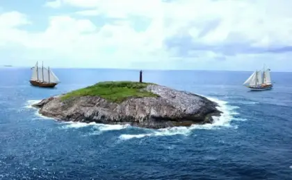 Vista aérea da Ilha Escalvada com seu farol vermelho, principal ponto de mergulho em Guarapari, Espírito Santo.
