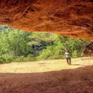 Entrada imponente da Gruta do Limoeiro em Castelo, Espírito Santo, com paredão de pedra e vegetação.