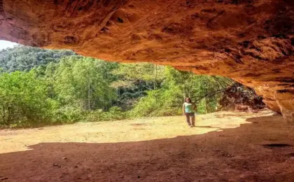 Entrada imponente da Gruta do Limoeiro em Castelo, Espírito Santo, com paredão de pedra e vegetação.