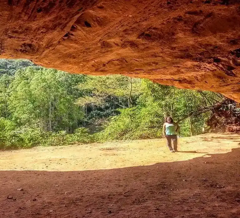Entrada imponente da Gruta do Limoeiro em Castelo, Espírito Santo, com paredão de pedra e vegetação.