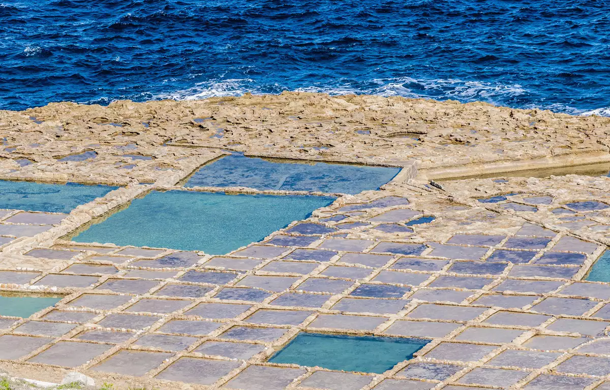 tanques de sal de Gozo em Xwejni Bay com piscinas geométricas na rocha e mar Mediterrâneo