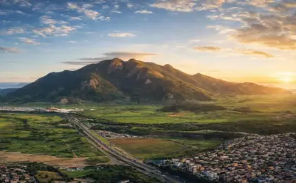 Mestre Álvaro: Guia completo para subir o gigante da Serra em 2026 16 Vista imponente do Mestre Álvaro na Serra, ES, com vegetação de Mata Atlântica e a cidade ao fundo.