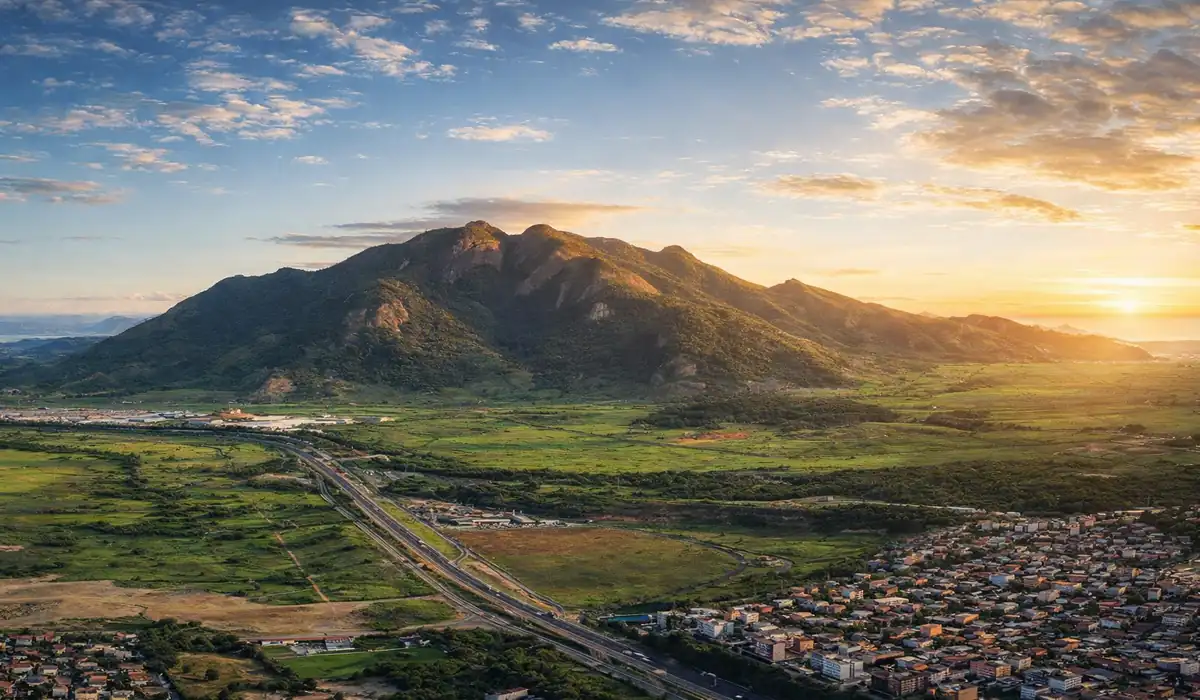 Mestre Álvaro: Guia completo para subir o gigante da Serra em 2026 8 Vista imponente do Mestre Álvaro na Serra, ES, com vegetação de Mata Atlântica e a cidade ao fundo.