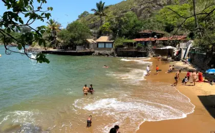 Barcos de pesca ancorados na Praia do Bananal em Vila Velha, com águas calmas e a Terceira Ponte ao fundo.