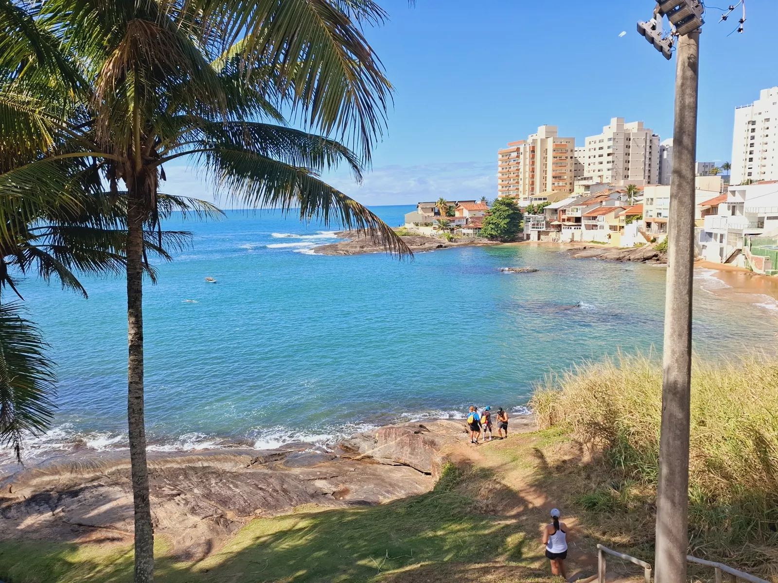 Caminhantes percorrendo praias no caminho dos Passos de Anchieta