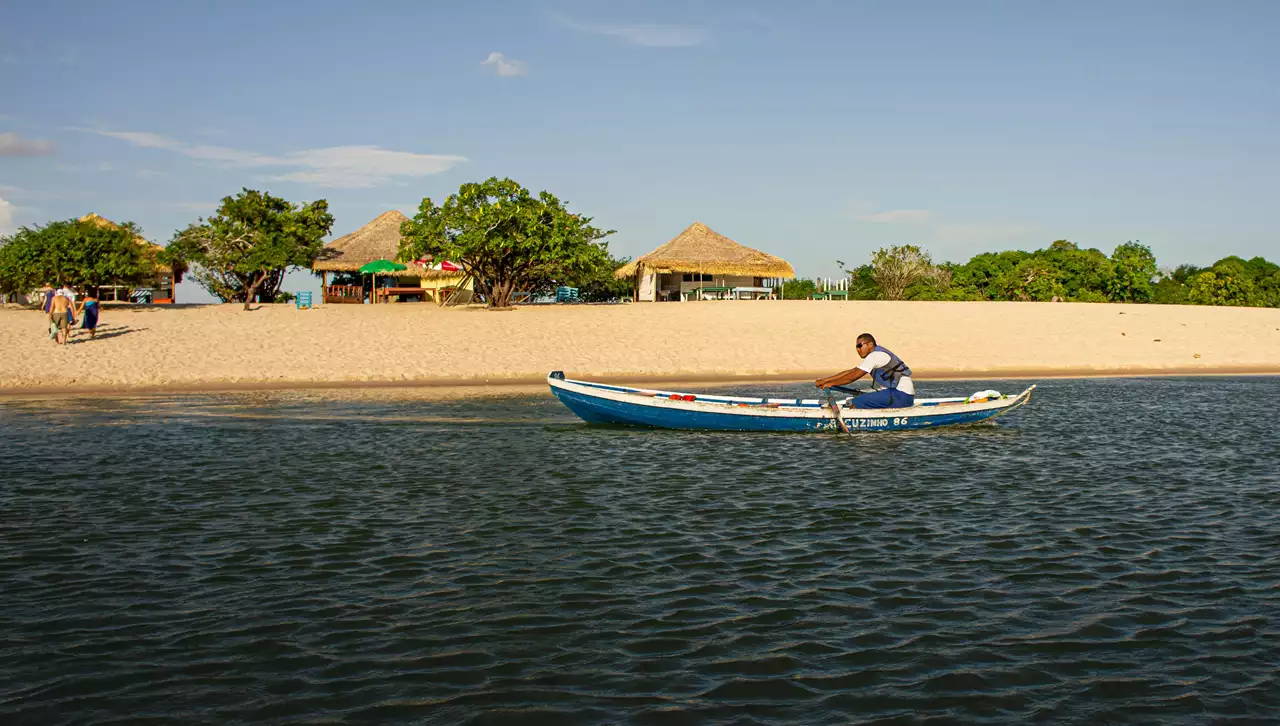 Barco diante de praia de areia clara em Alter do Chão