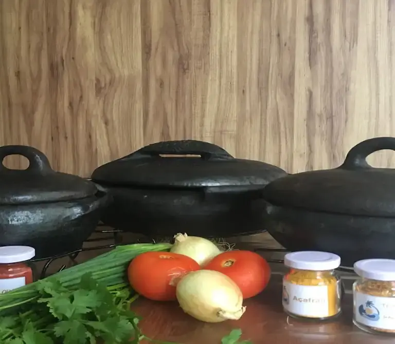 Artesãs das Paneleiras de Goiabeiras modelando panelas de barro manualmente no Galpão em Vitória.