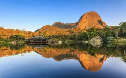 10 Pousadas em Pedra Azul que vão transformar sua viagem dos sonhos! 12 A famosa Pedra Azul refletida no lago durante o pôr do sol em Domingos Martins, cenário das melhores pousadas da região.