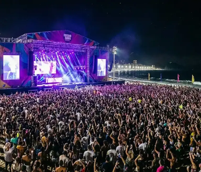 Palco da Arena de Verão em Vitória iluminado durante show gratuito na Praia de Camburi.