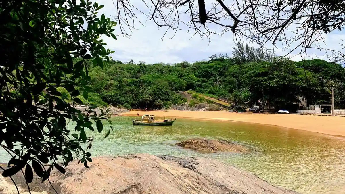 Família brincando na beira do mar calmo em uma praia do Espírito Santo, ideal para crianças.