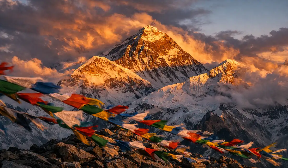 Monte Everest: O Lado Sombrio da "Zona da Morte 8 Pico do Monte Everest com nuvens dramáticas e bandeiras de oração, ilustrando o ambiente hostil da Zona da Morte.