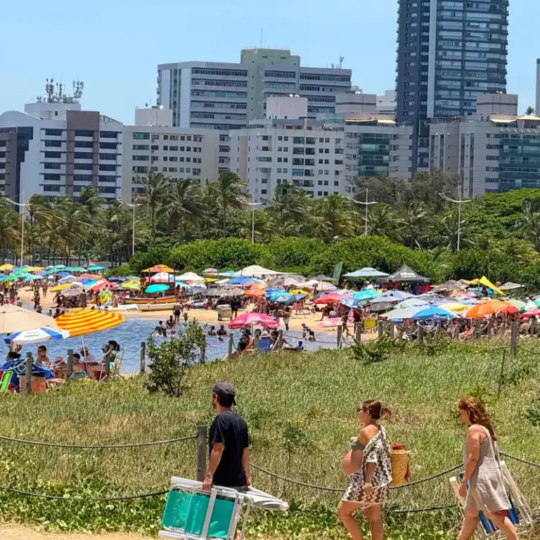 Multidão de banhistas na Praia da Guarderia em Vitória sob céu azul no dia 1º de janeiro de 2026.