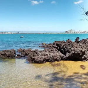 Águas cristalinas e corais na Praia Secreta de Camburi, em Vitória, em um dia de sol.