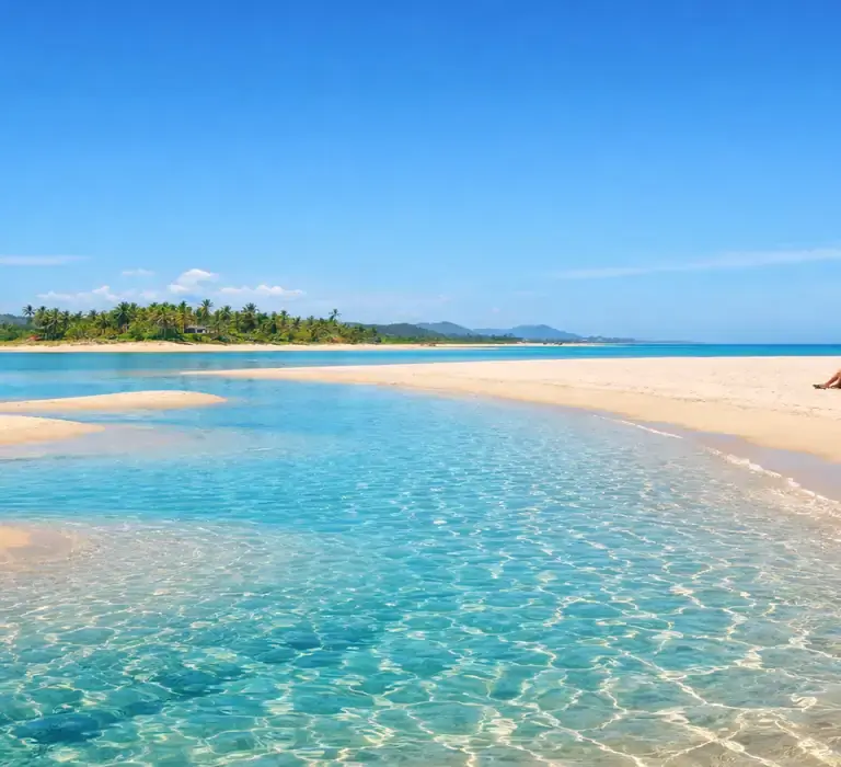 Paisagem panorâmica de uma praia paradisíaca e vazia no litoral do Espírito Santo, com mar calmo e areia branca, representando os refúgios longe da multidão.