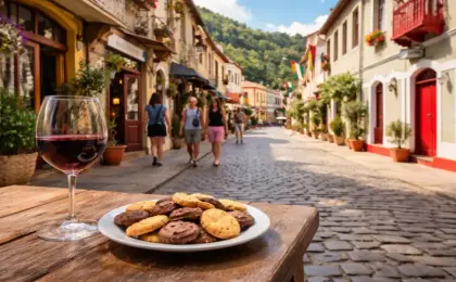 Rua de Lazer em Santa Teresa (ES) com arquitetura colonial preservada, taça de vinho e biscoitos artesanais em primeiro plano. Representação do roteiro de agroturismo na região serrana.