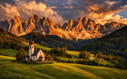 Igreja de Santa Maddalena em Val di Funes com as montanhas Odle ao fundo durante o pôr do sol.