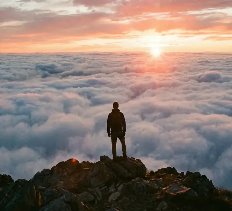 Foto tirada do topo do Mestre Álvaro acima das nuvens durante o nascer do sol, mostrando a vista panorâmica da Serra e Grande Vitória.