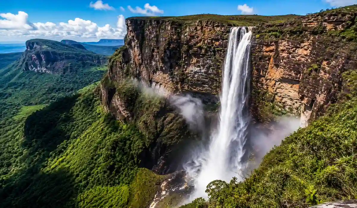 Cachoeira da Fumaça na Chapada Diamantina com paredão alto e queda sendo levada pelo vento