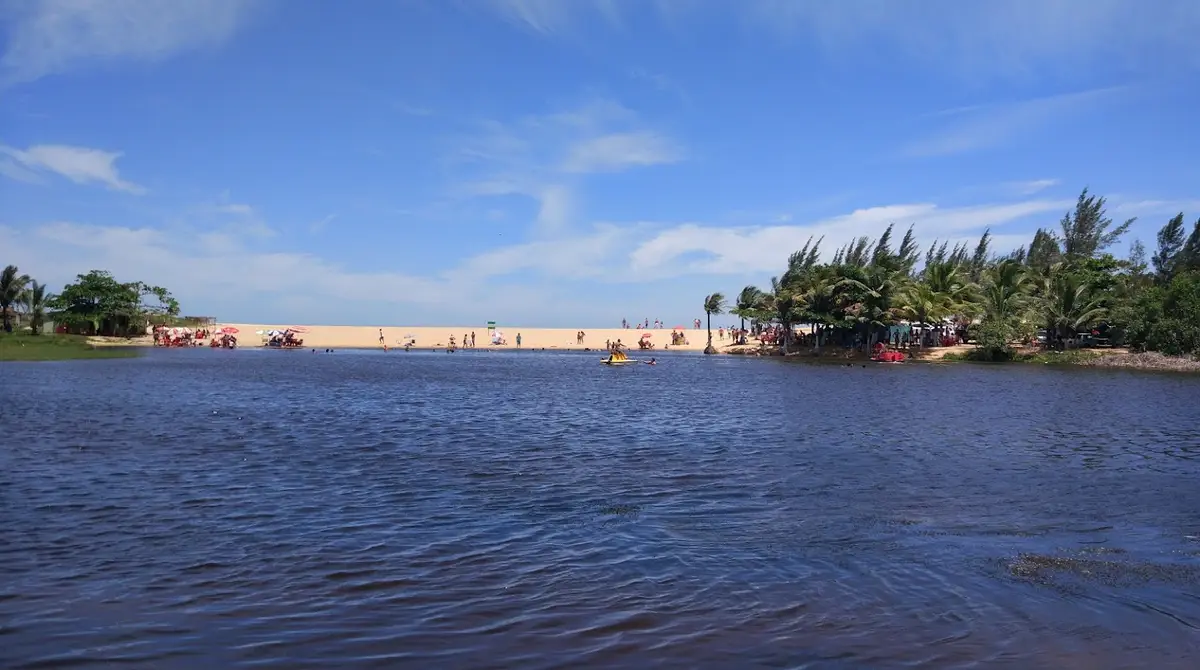 Lagoa de Boa Vista em Marataízes com vegetação, faixa de areia e embarcações
