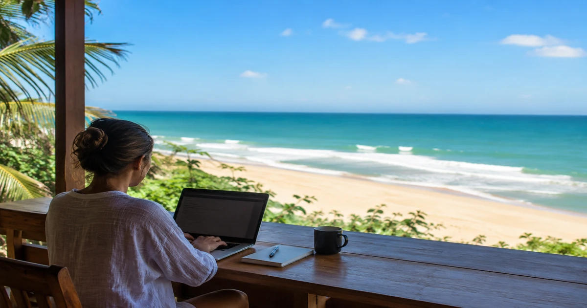 Pessoa trabalhando remotamente com notebook e vista no Espírito Santo